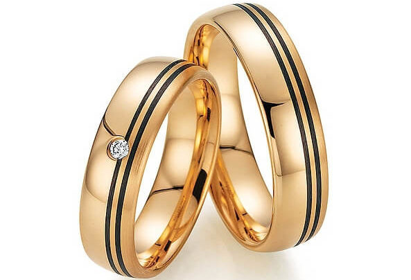 Golden wedding rings with two black stripes