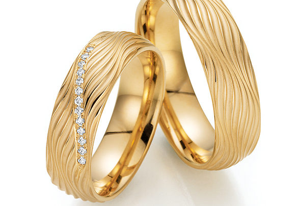 Golden wedding rings with wave pattern