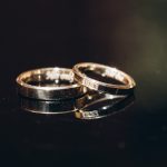 Two gold rings with gemstone and engraving on a black background